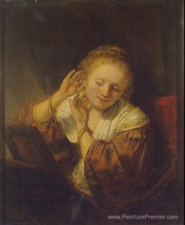 Jeune femme essayant des boucles d'oreilles