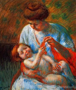 Bébé allongé sur les genoux de sa mère, atteignant pour tenir un Bébé allongé sur les genoux de sa mère, atteignant pour tenir un