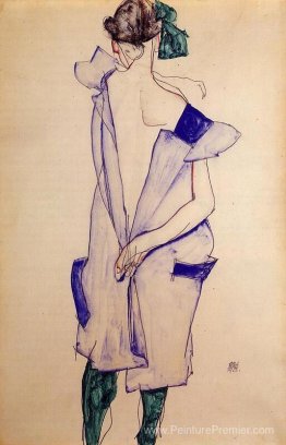 Fille debout dans une robe bleue et bas vert, vue arrière Fille debout dans une robe bleue et bas vert, vue arrière