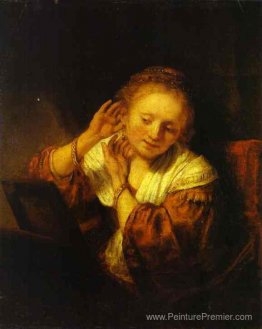Une jeune femme essayant des boucles d'oreilles Une jeune femme essayant des boucles d'oreilles